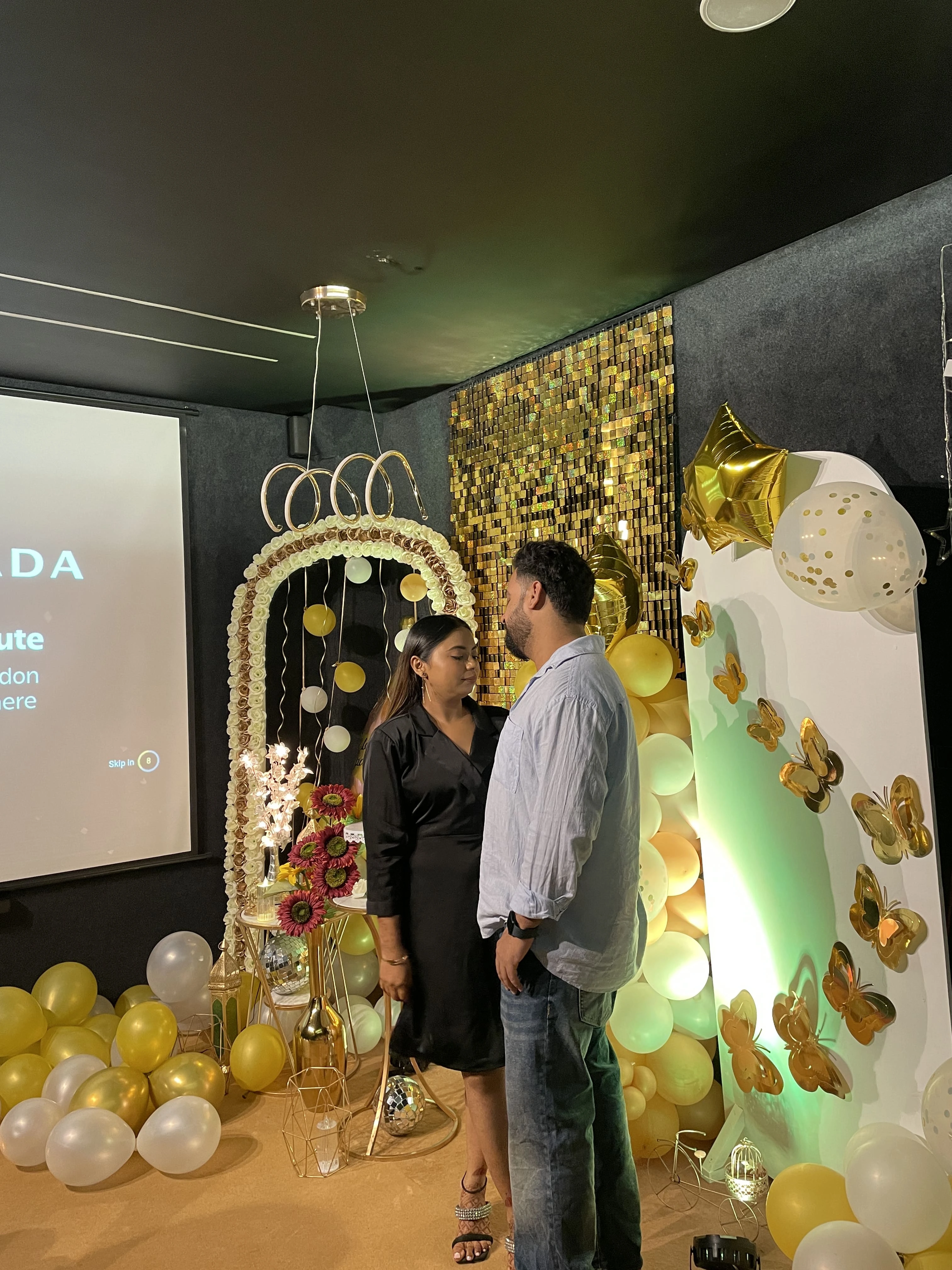 Couple watching a movie projected on a wall with popcorn